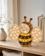 Lampe Abeille ORAWOOD, allumée sur une étagère en lumière naturelle