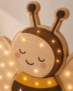 Lampe Abeille ORAWOOD, gros plan du visage, du bois et des points lumineux