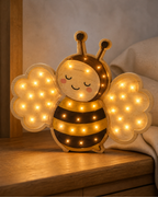 Lampe Abeille ORAWOOD, allumée dans une ambiance de chambre au crépuscule
