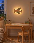ORAWOOD airplane wall-light 30x22 display detail 2026-09-28 2/5 — Lampe Avion murale, mise en scène illustrative : Chambre d’enfant au crépuscule, halo arrière allumé, dimensions de présentation 30 × 22 cm