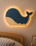 Visualisation illustrative de la lampe Baleine murale ORAWOOD en pin, bleu nuit, avec halo lumineux arrière